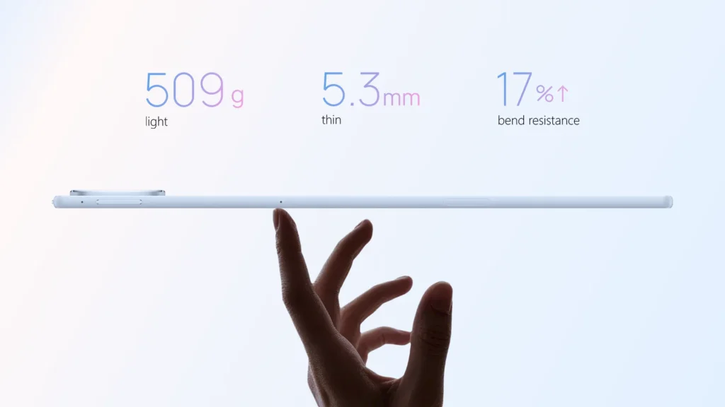 Side view of the ultra-thin light blue HUAWEI MatePad Air balancing horizontally on a person's index finger, highlighting key specifications: 509g light weight, 5.3mm thinness, and 17% higher bend resistance.