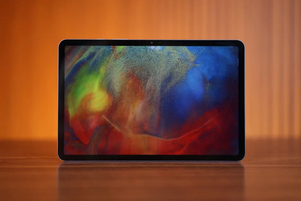 Front view of the Infinix XPAD 30 Pro tablet placed horizontally, displaying a colorful, abstract wallpaper with vibrant swirls of red, blue, green, and yellow on its screen.