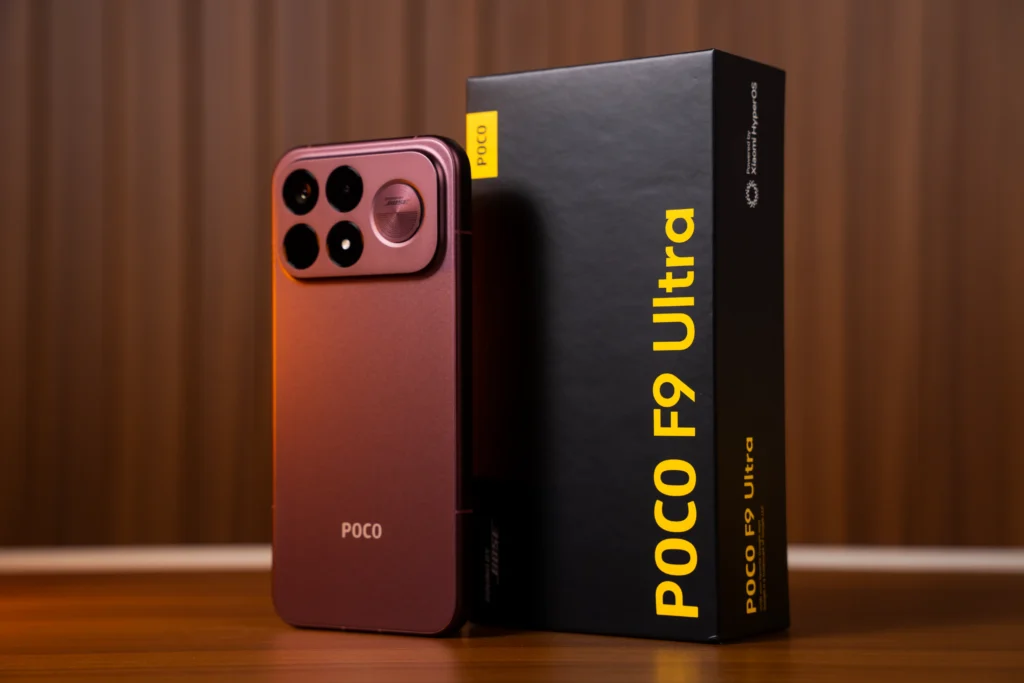 Red/dark cherry POCO F9 Ultra smartphone shown standing next to its black retail box featuring yellow branding text.