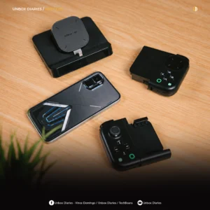 Top-down view on a light wooden table showcasing an Infinix GT gaming smartphone, a black desktop cooling dock, and a split mobile gaming controller separated into left and right grip modules, with Unbox Diaries branding at the top and social media handles listed along the bottom edge.