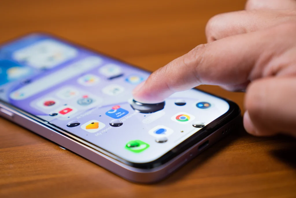 A close-up view of a person using a finger on the touchscreen of the HONOR 600S 5G smartphone.