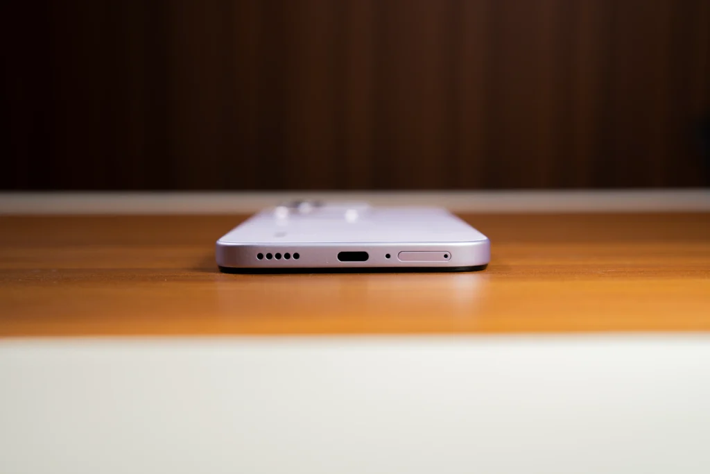 A bottom edge view of the purple HONOR 600S 5G displaying the speaker grille, USB Type-C port, microphone hole, and SIM tray slot.